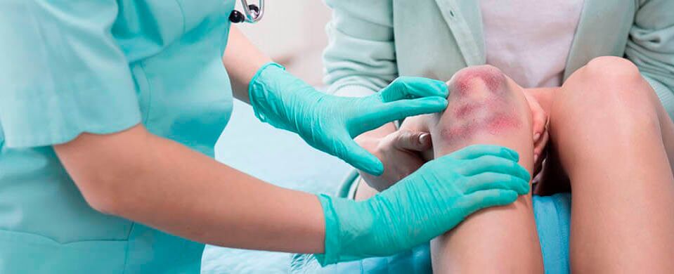 Médico revisa lesión de rodilla